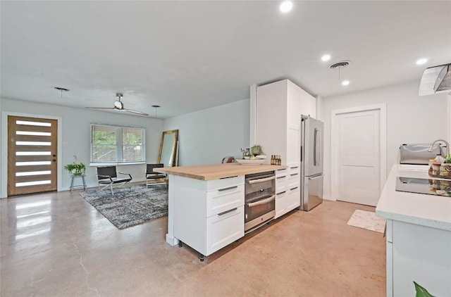 4505 Dudley Dr, Austin, TX 78735 - kitchen featuring freestanding refrigerator, concrete floors, white cabinetry, recessed lighting, and butcher block counters