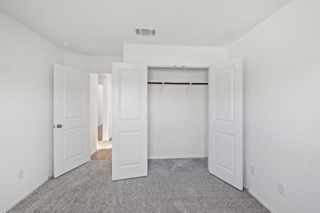 unfurnished bedroom with carpet flooring and a closet