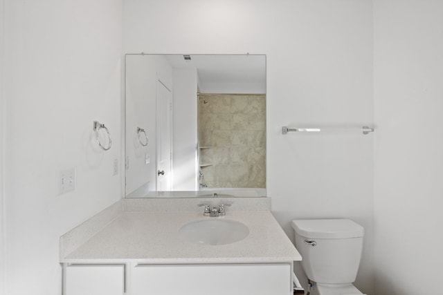 bathroom with walk in shower, vanity, and toilet