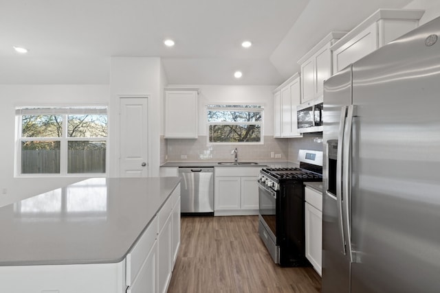 kitchen featuring white cabinetry, sink, appliances with stainless steel finishes, and tasteful backsplash