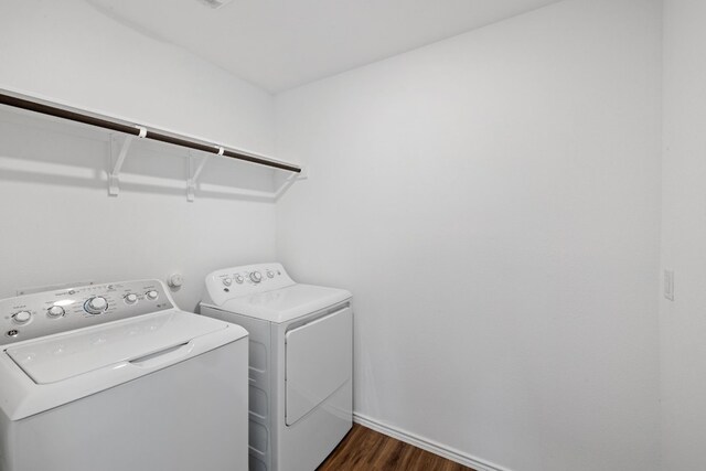 laundry area with separate washer and dryer and dark wood-type flooring