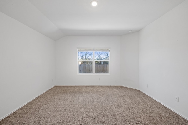 unfurnished room with carpet and lofted ceiling