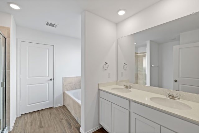 bathroom featuring hardwood / wood-style floors, vanity, and separate shower and tub