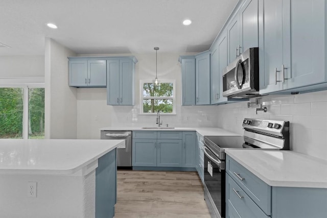 kitchen with decorative light fixtures, stainless steel appliances, plenty of natural light, and sink