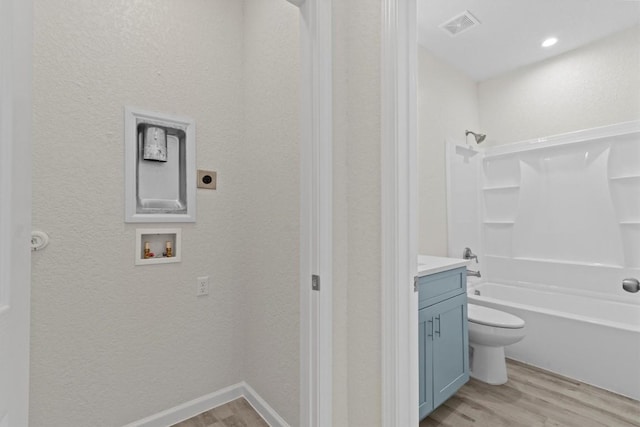 full bathroom with bathtub / shower combination, hardwood / wood-style floors, vanity, and toilet