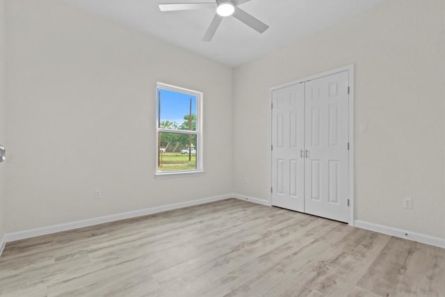 unfurnished bedroom featuring ceiling fan, a closet, and light hardwood / wood-style floors