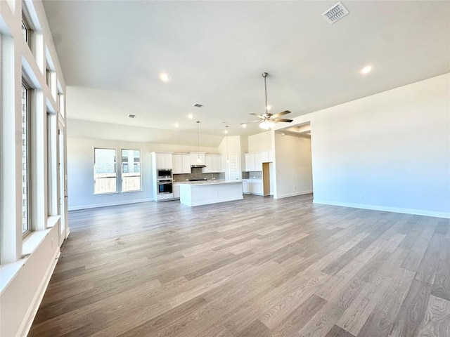 unfurnished living room with ceiling fan and light hardwood / wood-style floors