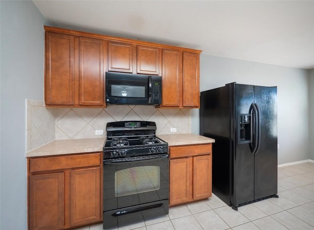 kitchen with black appliances, decorative backsplash, and light tile patterned floors