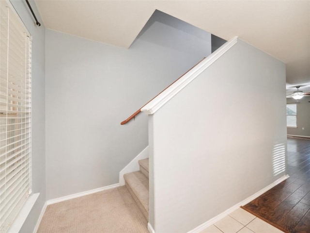 staircase with ceiling fan and tile patterned flooring