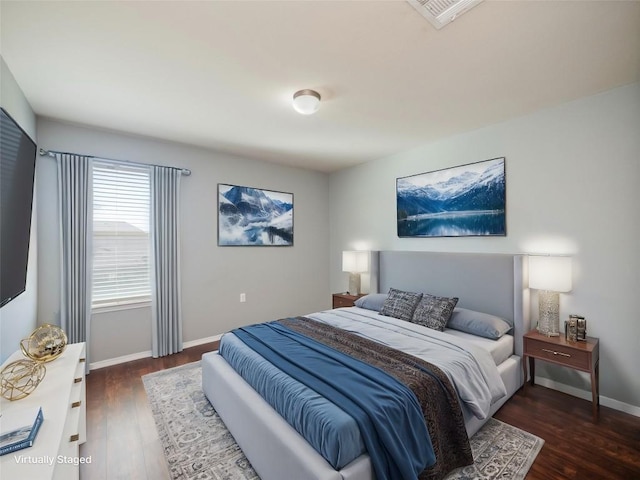 bedroom with dark hardwood / wood-style floors