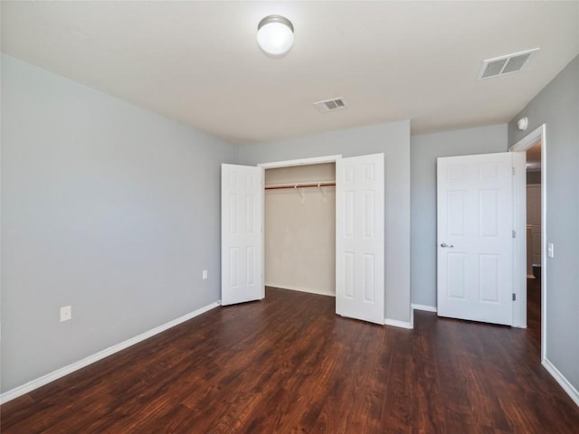 unfurnished bedroom with dark wood-type flooring and a closet