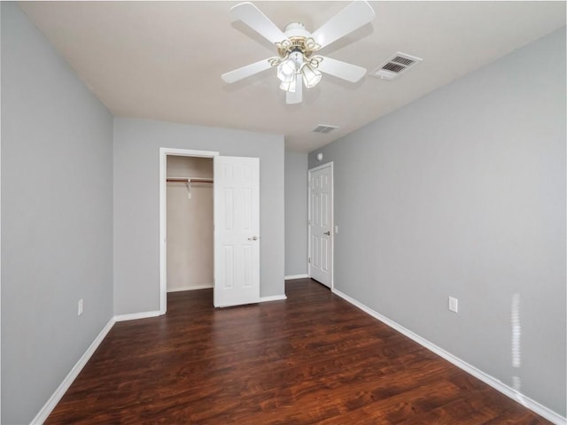 unfurnished bedroom with ceiling fan and dark wood-type flooring