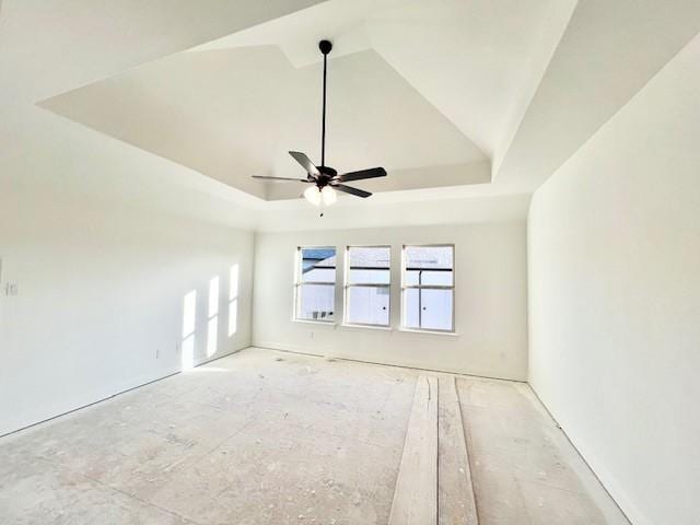 unfurnished room with ceiling fan and a raised ceiling