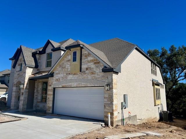 view of front facade with central AC and a garage