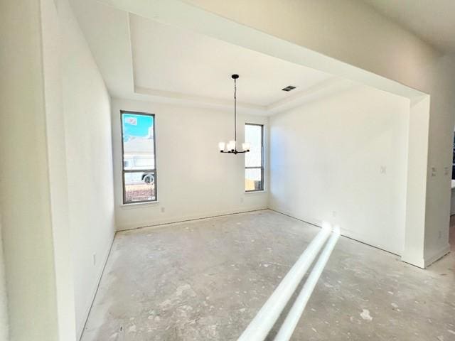 unfurnished dining area with a raised ceiling and an inviting chandelier