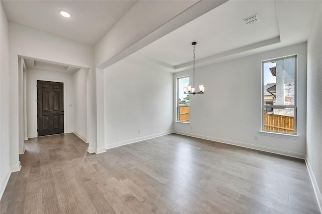 2204 Bayridge Rd, Georgetown, TX 78628 - unfurnished room with a chandelier, wood finished floors, baseboards, a tray ceiling, and recessed lighting