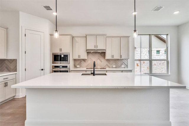 2204 Bayridge Rd, Georgetown, TX 78628 - kitchen with stainless steel oven, built in microwave, a sink, decorative backsplash, and light countertops