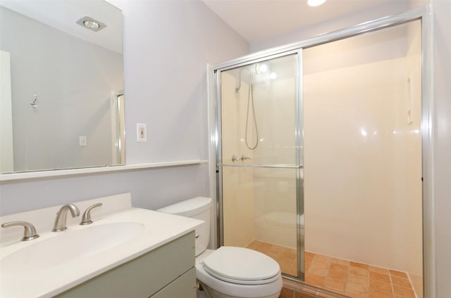 bathroom featuring vanity, toilet, and a shower with shower door