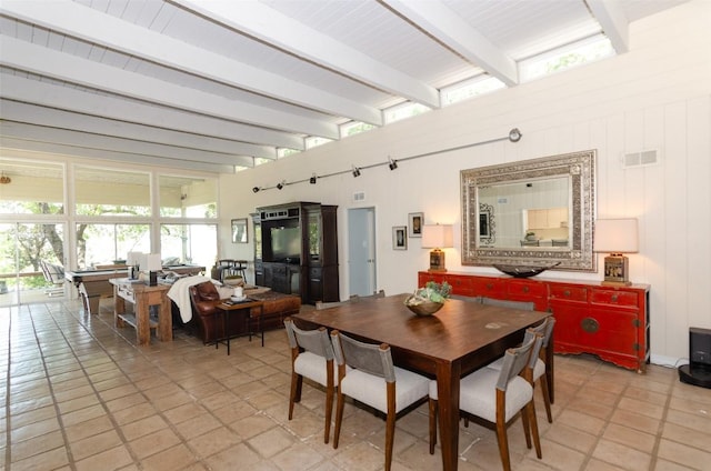 tiled dining area featuring beamed ceiling