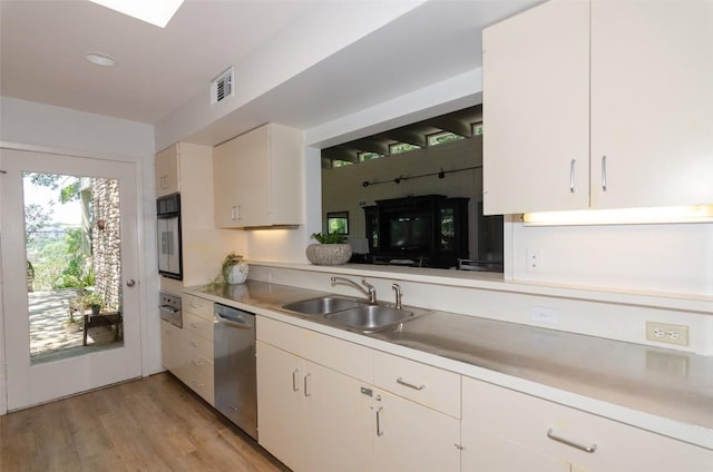 kitchen with dishwasher, white cabinets, light hardwood / wood-style floors, and sink