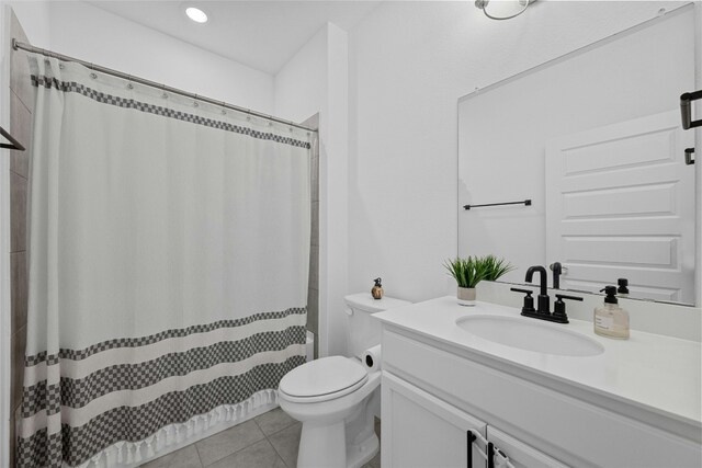 bathroom featuring vanity, tile patterned floors, and toilet