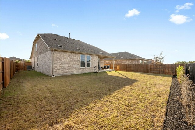 back of house with a lawn and central air condition unit