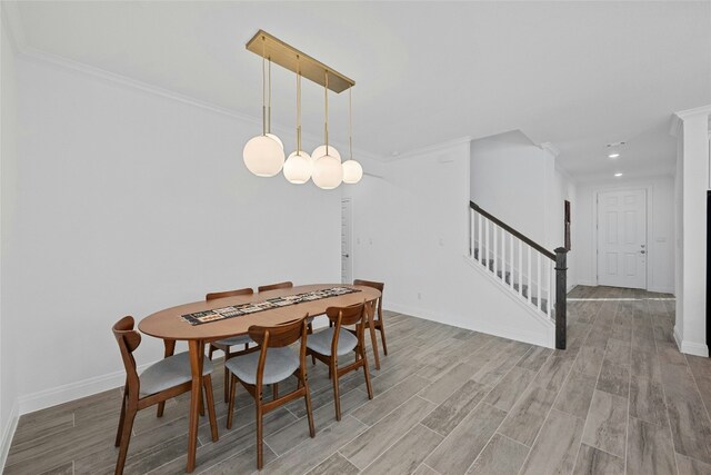 dining room with crown molding and light hardwood / wood-style floors