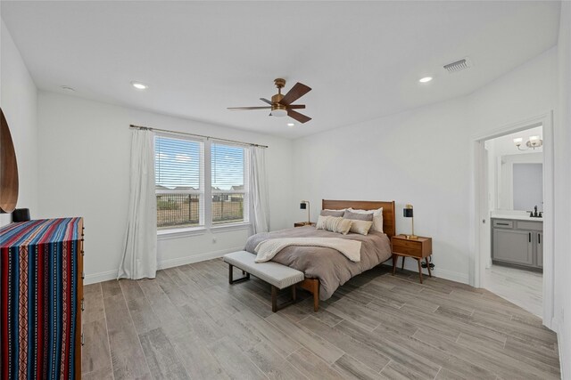 bedroom with sink, ceiling fan with notable chandelier, and light wood-type flooring