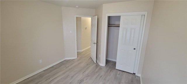 unfurnished bedroom featuring a closet and light wood-type flooring