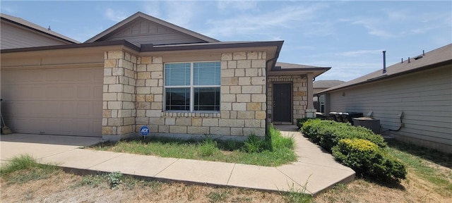 view of front of home featuring a garage and central air condition unit