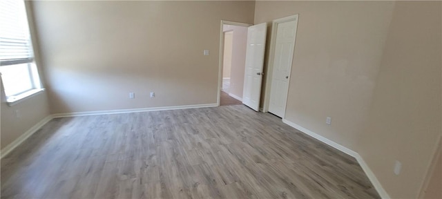 empty room with light hardwood / wood-style flooring