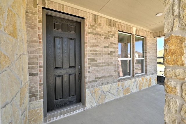 doorway to property with brick siding