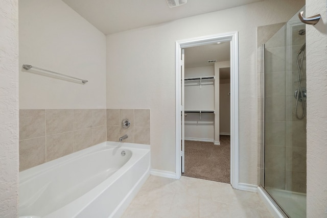 bathroom with tile patterned floors and shower with separate bathtub