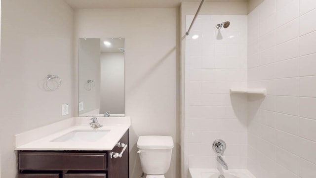 full bathroom featuring vanity, tiled shower / bath combo, and toilet