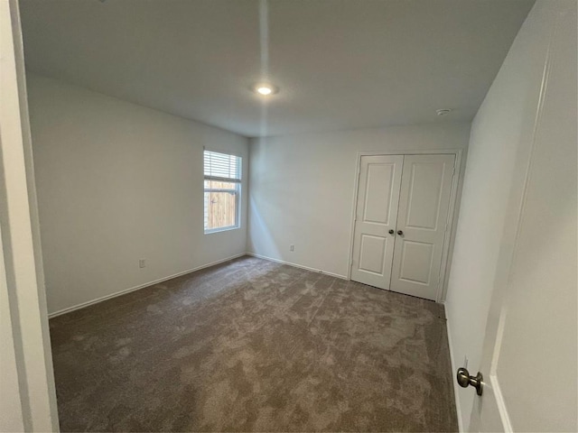 empty room featuring dark carpet