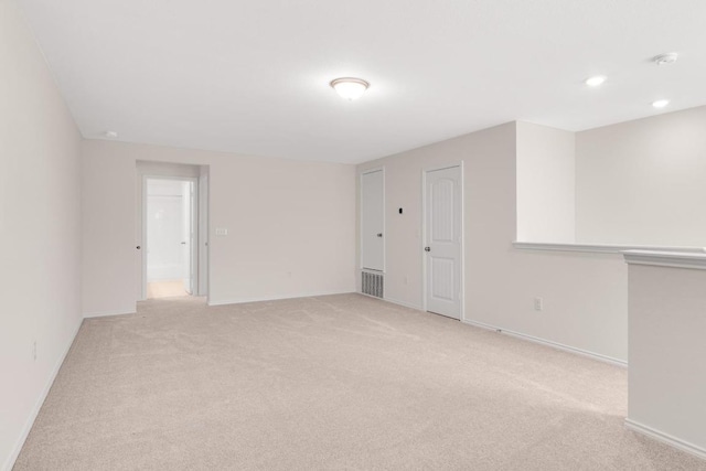 unfurnished room featuring recessed lighting, baseboards, and light carpet