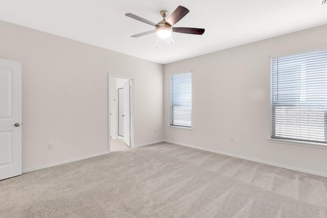 empty room featuring baseboards, light carpet, plenty of natural light, and ceiling fan