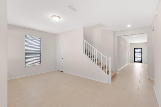 spare room featuring visible vents, baseboards, stairway, recessed lighting, and light tile patterned flooring