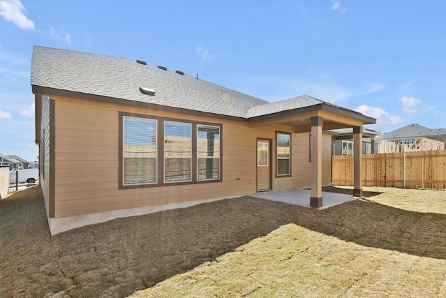 back of property featuring a patio area, roof with shingles, and fence