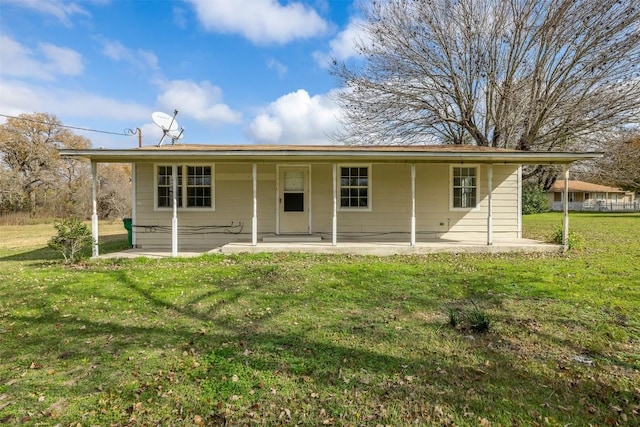 rear view of house featuring a patio area and a yard