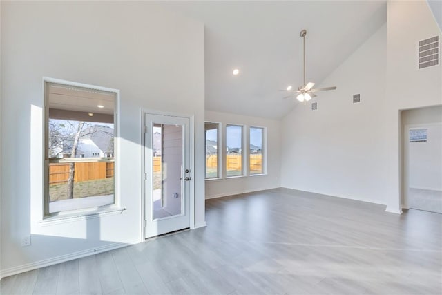 unfurnished living room featuring ceiling fan, high vaulted ceiling, wood finished floors, and visible vents