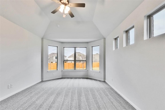 carpeted empty room featuring vaulted ceiling, baseboards, and ceiling fan