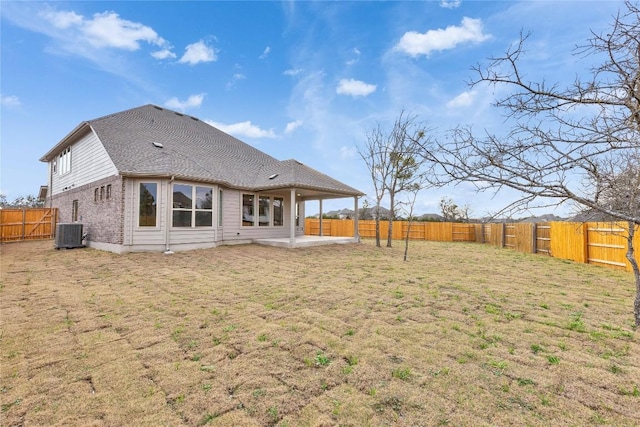 back of house with a patio, a fenced backyard, cooling unit, a yard, and brick siding