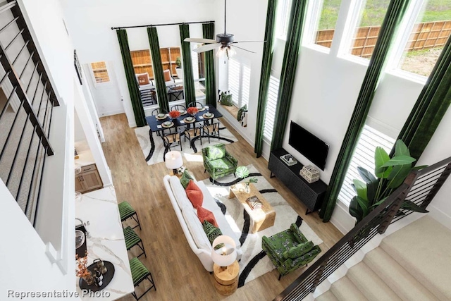 living room featuring ceiling fan and light hardwood / wood-style floors