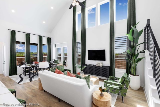 living room with light hardwood / wood-style floors and high vaulted ceiling