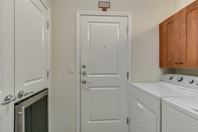 clothes washing area featuring washer and clothes dryer and cabinets