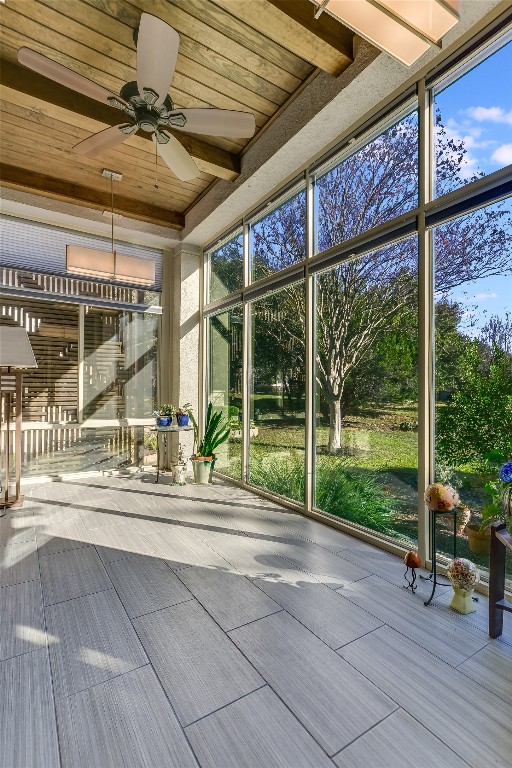 unfurnished sunroom featuring ceiling fan and wood ceiling