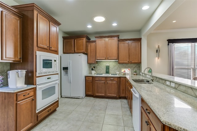 kitchen featuring white appliances, crown molding, sink, decorative backsplash, and light stone counters