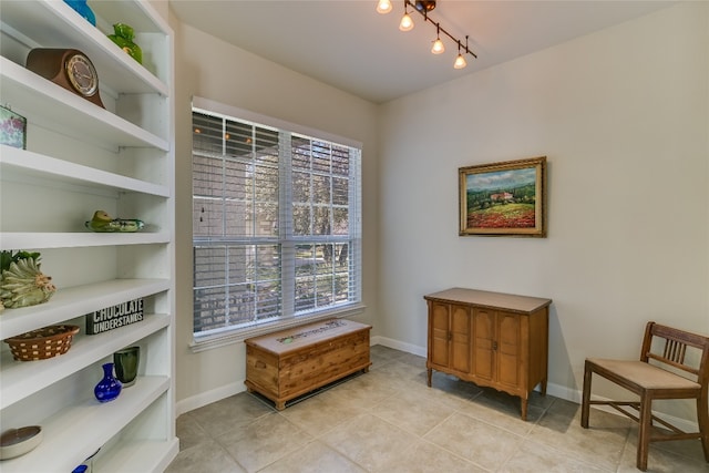 sitting room with built in shelves, plenty of natural light, and light tile patterned flooring