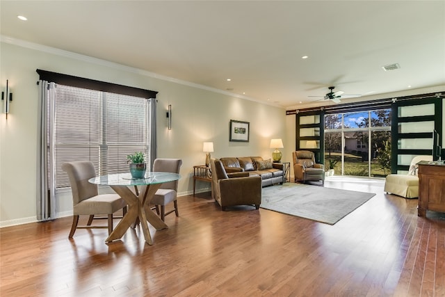 living room featuring hardwood / wood-style flooring, ceiling fan, and ornamental molding